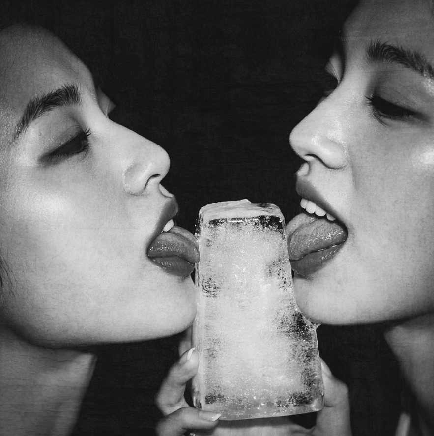 Erotic fine art photograph of two mirrored faces touching ice, symbolizing desire, shadow, and psychological reflection.