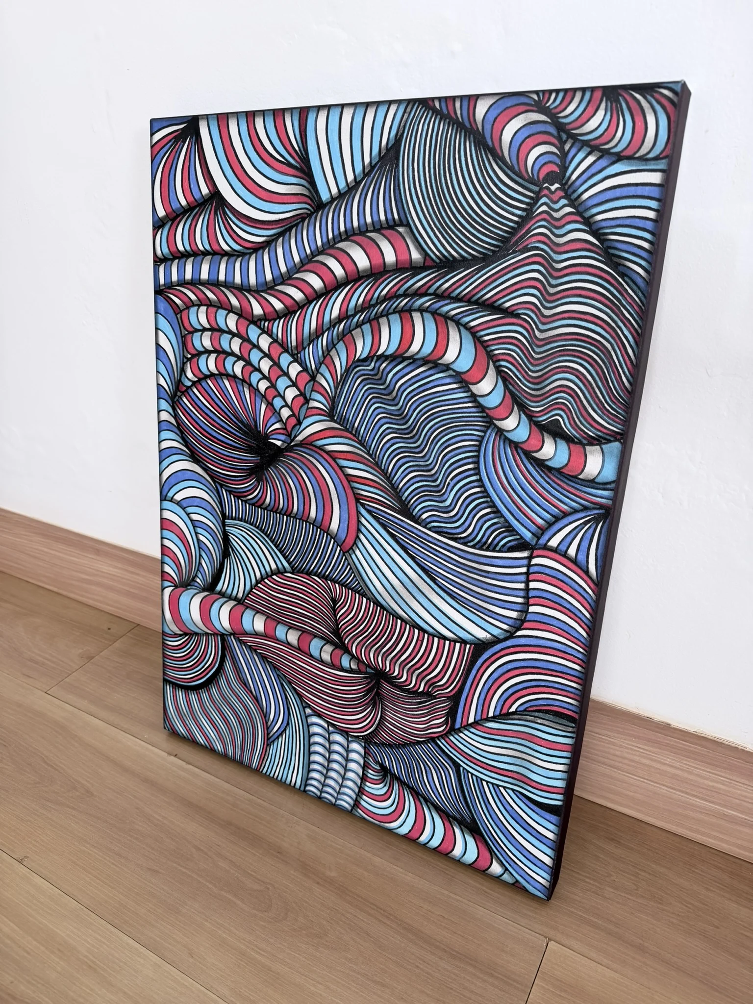 Chromatic Currents is an original one-of-a-kind painting on canvas created with marker, ink and pastel. A dense network of red, blue, black and white lines moves across the surface in continuous waves, folds and interlocking forms. Each hand-drawn band follows its own trajectory, yet together they construct a highly controlled visual system in which the canvas appears to expand, contract and shift in depth. The composition combines the graphic intensity of optical abstraction with a distinctly organic rhythm. Lines curve around one another, compress into narrow passages and open into larger volumes, transforming a flat surface into an almost sculptural field of movement. From a distance, the strong red and blue palette creates immediate impact. Viewed more closely, the individual marks reveal the complexity and physical process behind the work. The result is an artwork that changes with proximity and rewards sustained viewing. Chromatic Currents is conceived as more than decoration. Its scale of movement, chromatic contrast and dense visual structure give it the power to define an environment. In a contemporary residence, private collection, executive interior or architectural setting, the painting becomes a central visual presence rather than a secondary accent. For collectors seeking original contemporary abstract painting, optical art and distinctive mixed-media work, Chromatic Currents offers both immediate graphic strength and the unmistakable individuality of a hand-created canvas. Medium: Painting, Marker / Ink / Pastel on Canvas Original: One-of-a-kind artwork Signature: Hand-signed by the artist Shipping: Free Shipping SEO Keywords abstract painting, optical art, op art, contemporary art, mixed media, canvas painting, marker art, ink art, pastel art, statement art, collectible art, luxury art, interior art, original painting